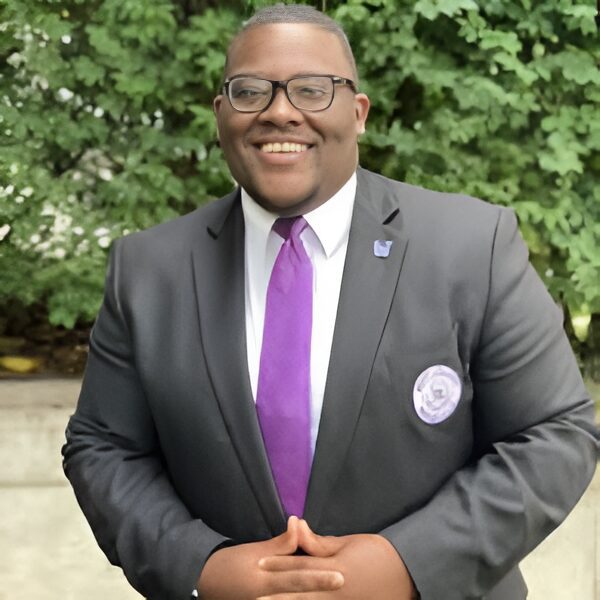 Man in suit with purple tie smiling